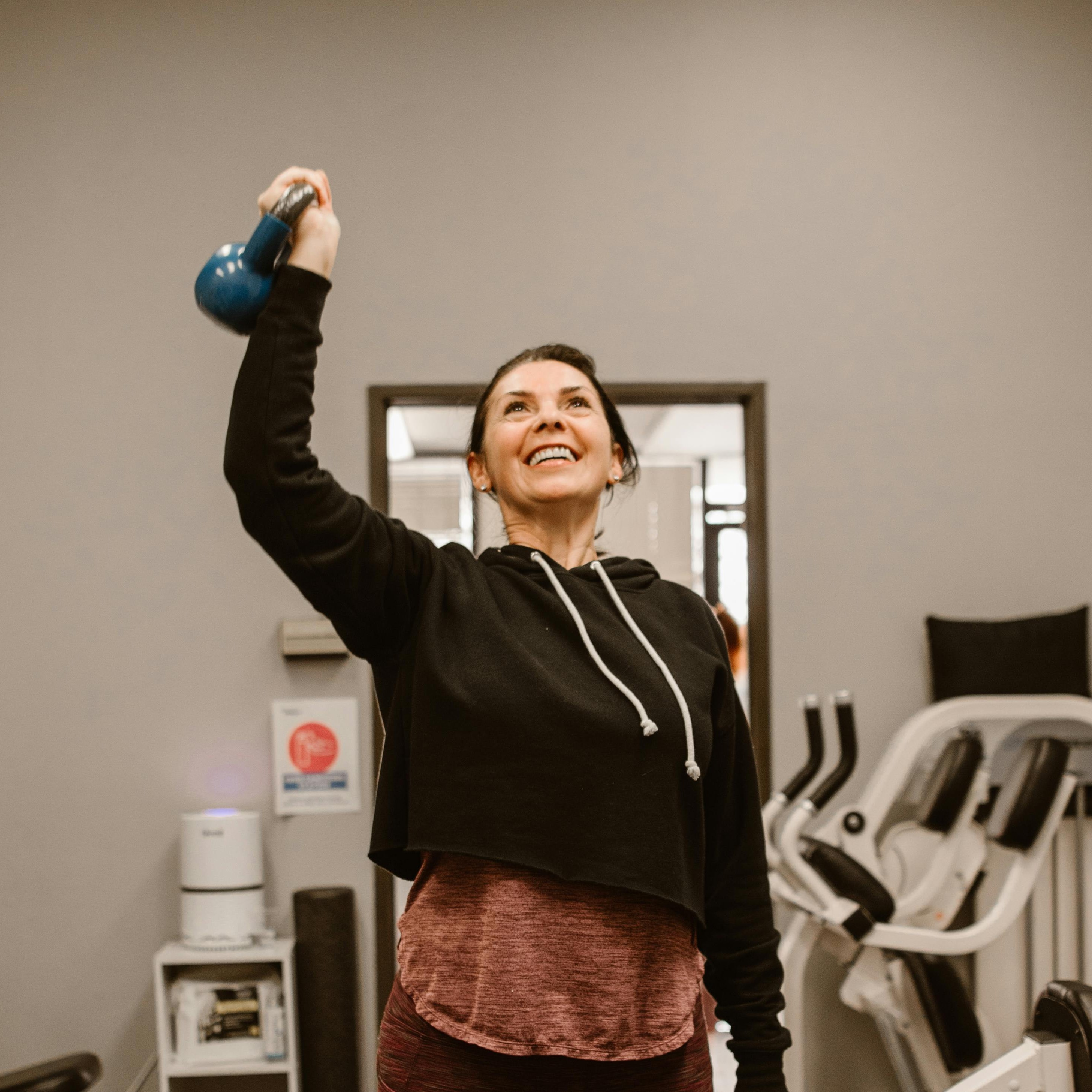 Woman doing kettlebell training in gym - professional fitness coaching by ReverseItFitness